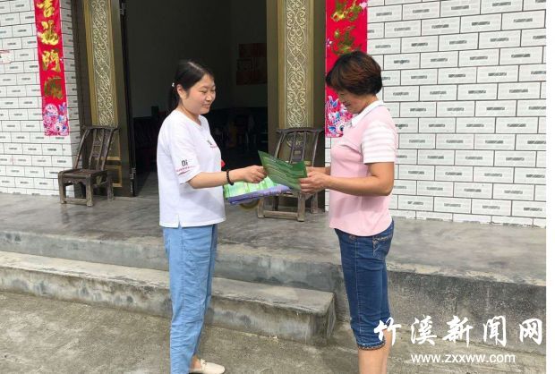 志愿者向群众发放公筷公勺宣传画册