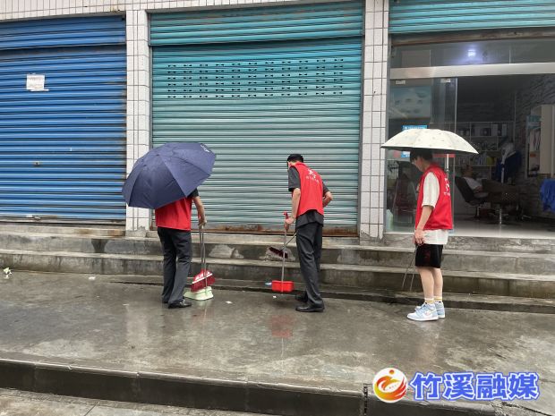 新党员冒着大雨清扫街道