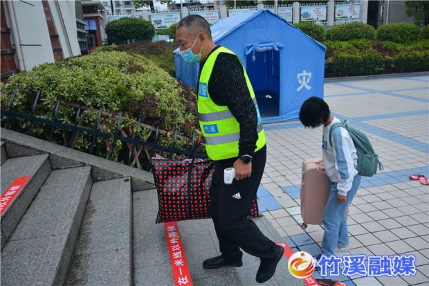 4志愿者帮助学生提行李